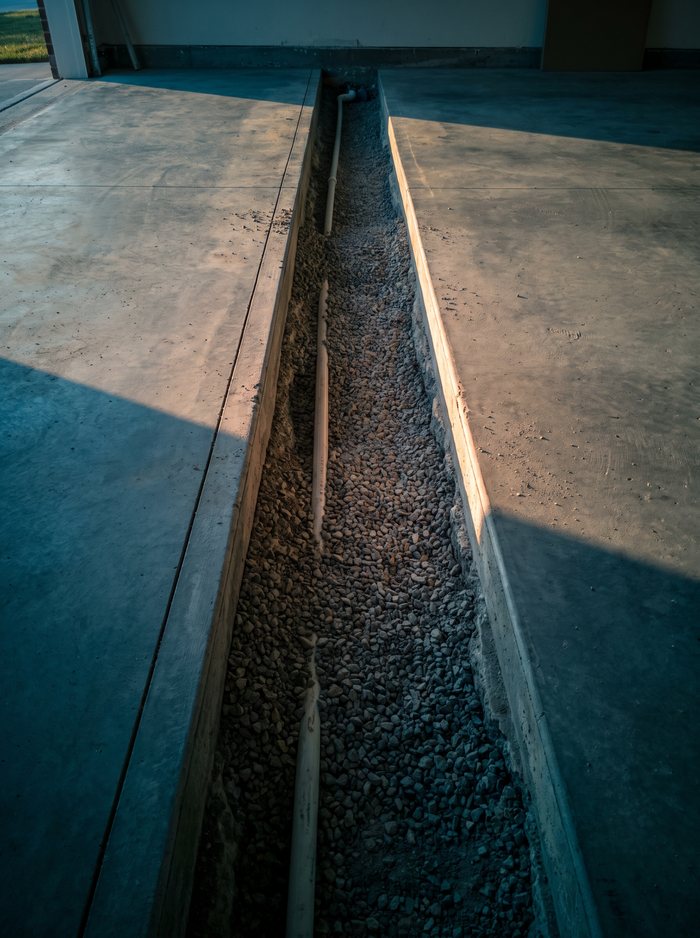 Illustration: a narrow saw-cut trench through a garage floor